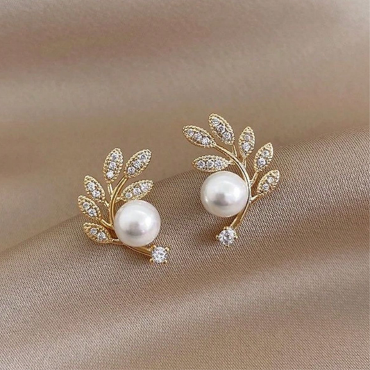 Gold-toned, leaf-shaped stud earrings featuring simulated pearls and cubic zirconia accents.